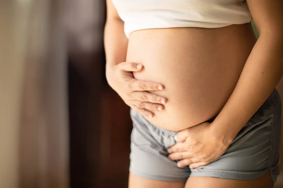 Woman resting a hand on her pregnant belly
