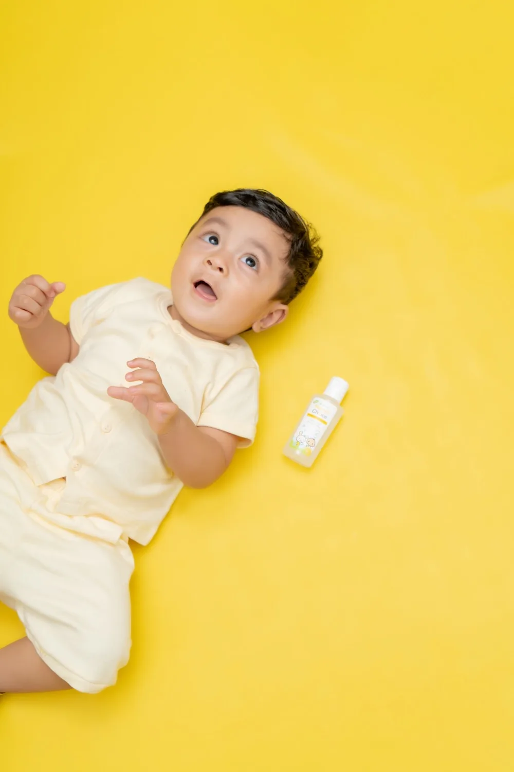 Bayi dengan krim wajah khusus bayi di sampingnya