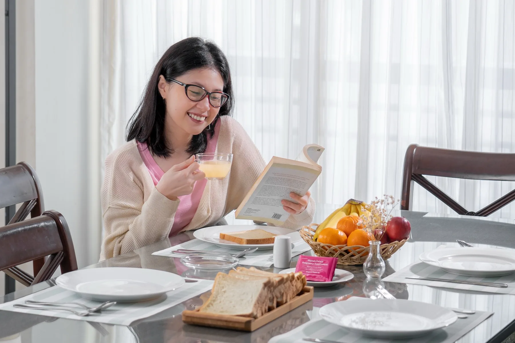 Mama sarapan sambil membaca di meja makan