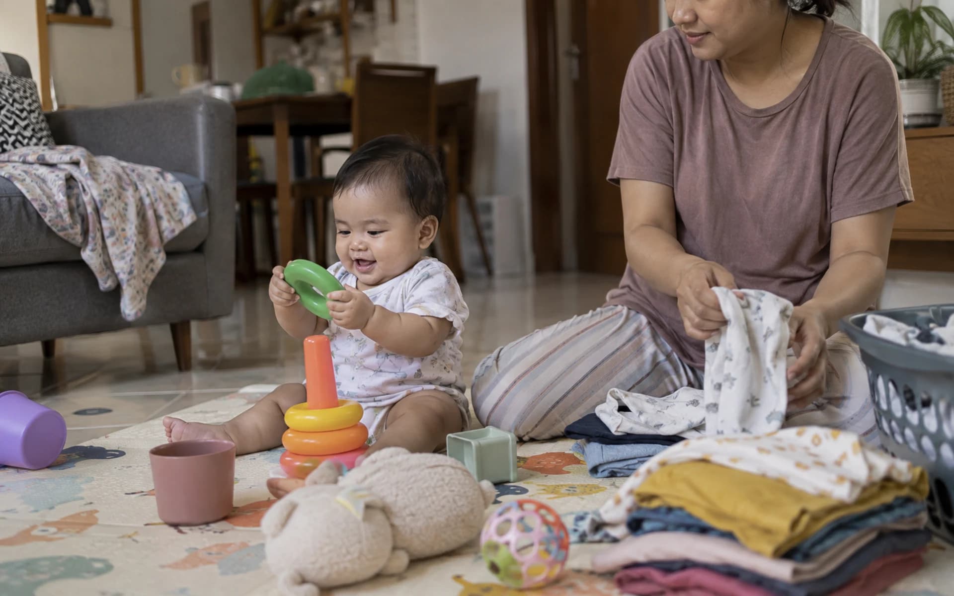 Bayi bermain di lantai bersama orang tuanya di rumah