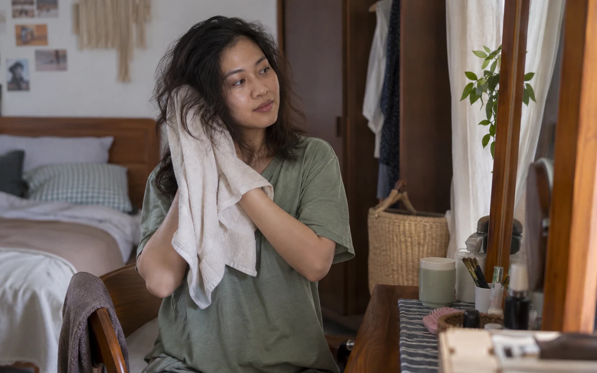 Perempuan mengeringkan rambut dengan handuk di kamar