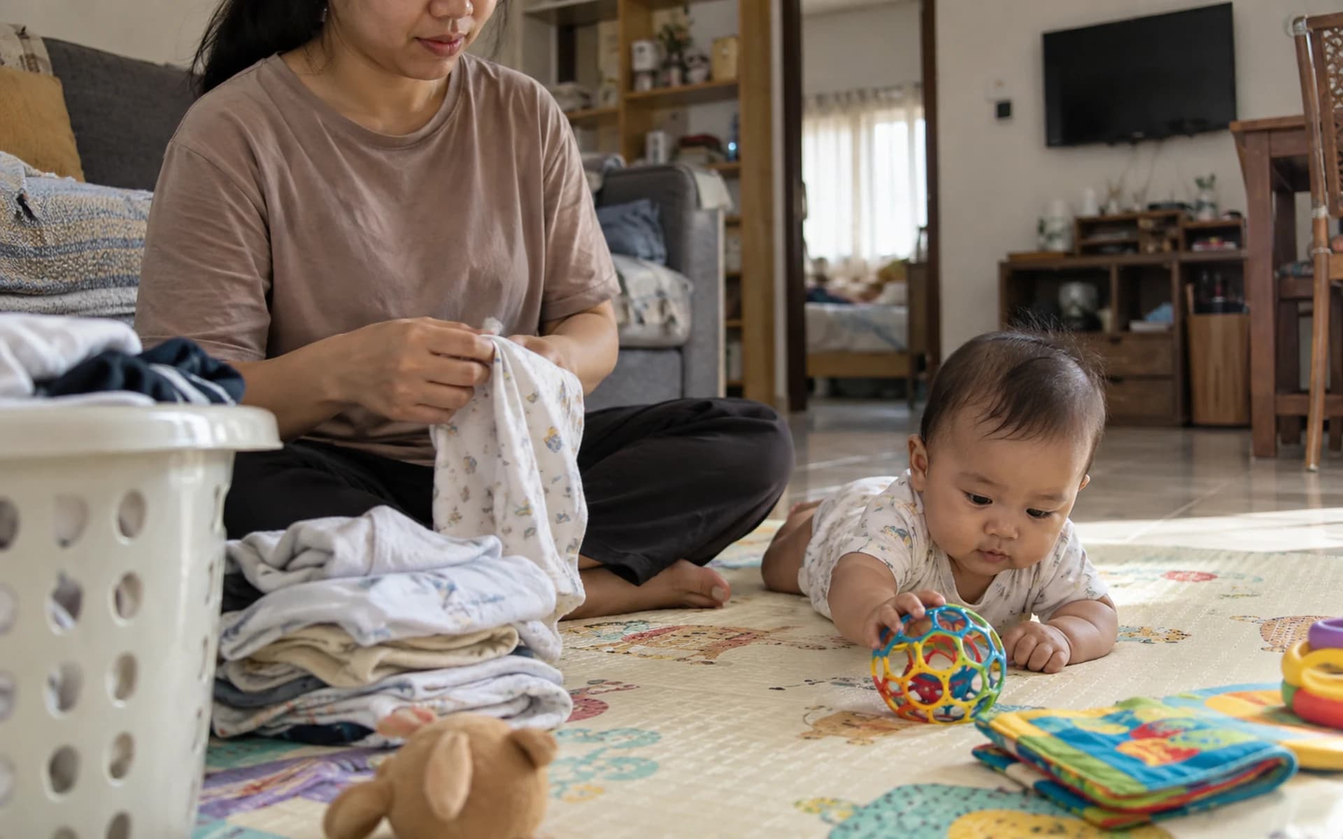 Bayi bermain di lantai bersama orang tuanya di rumah