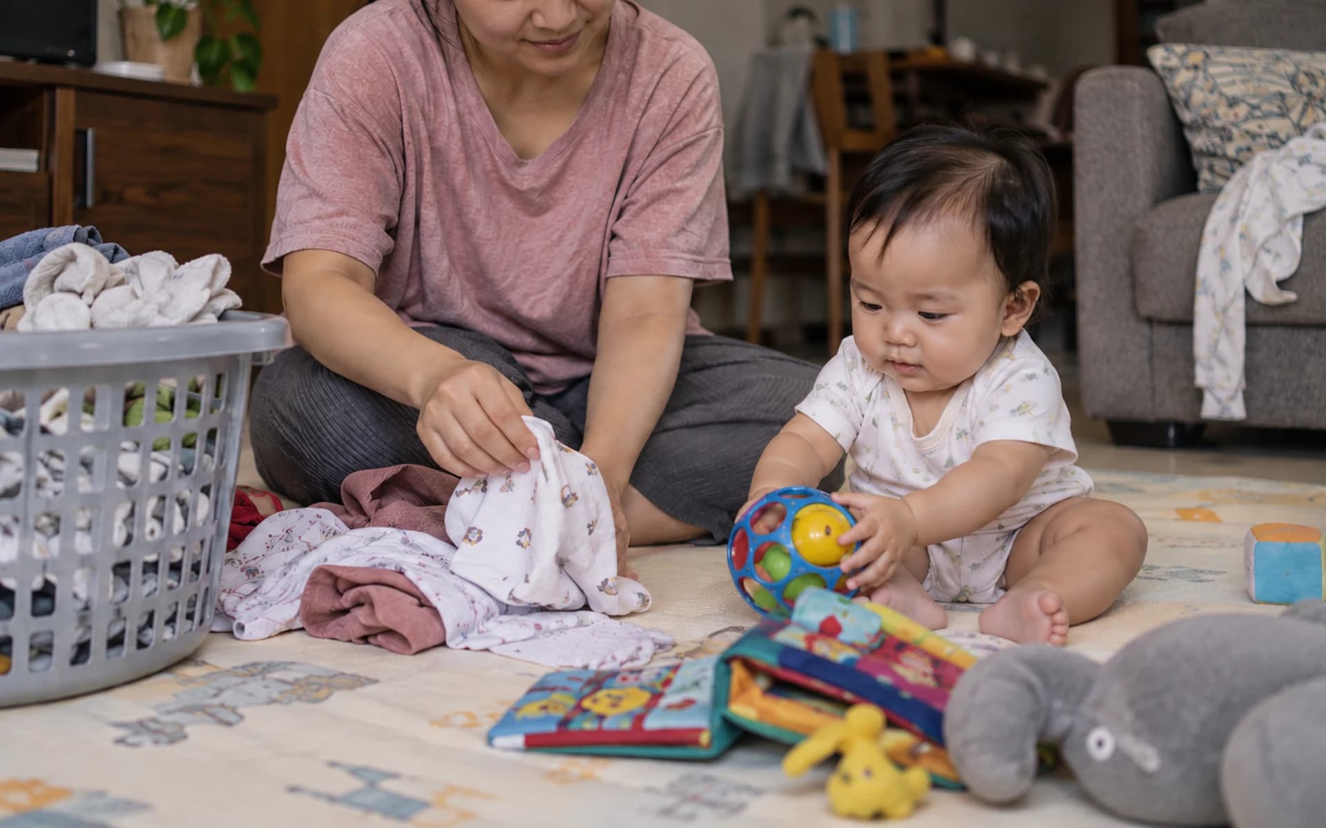 Bayi bermain di lantai bersama orang tuanya di rumah