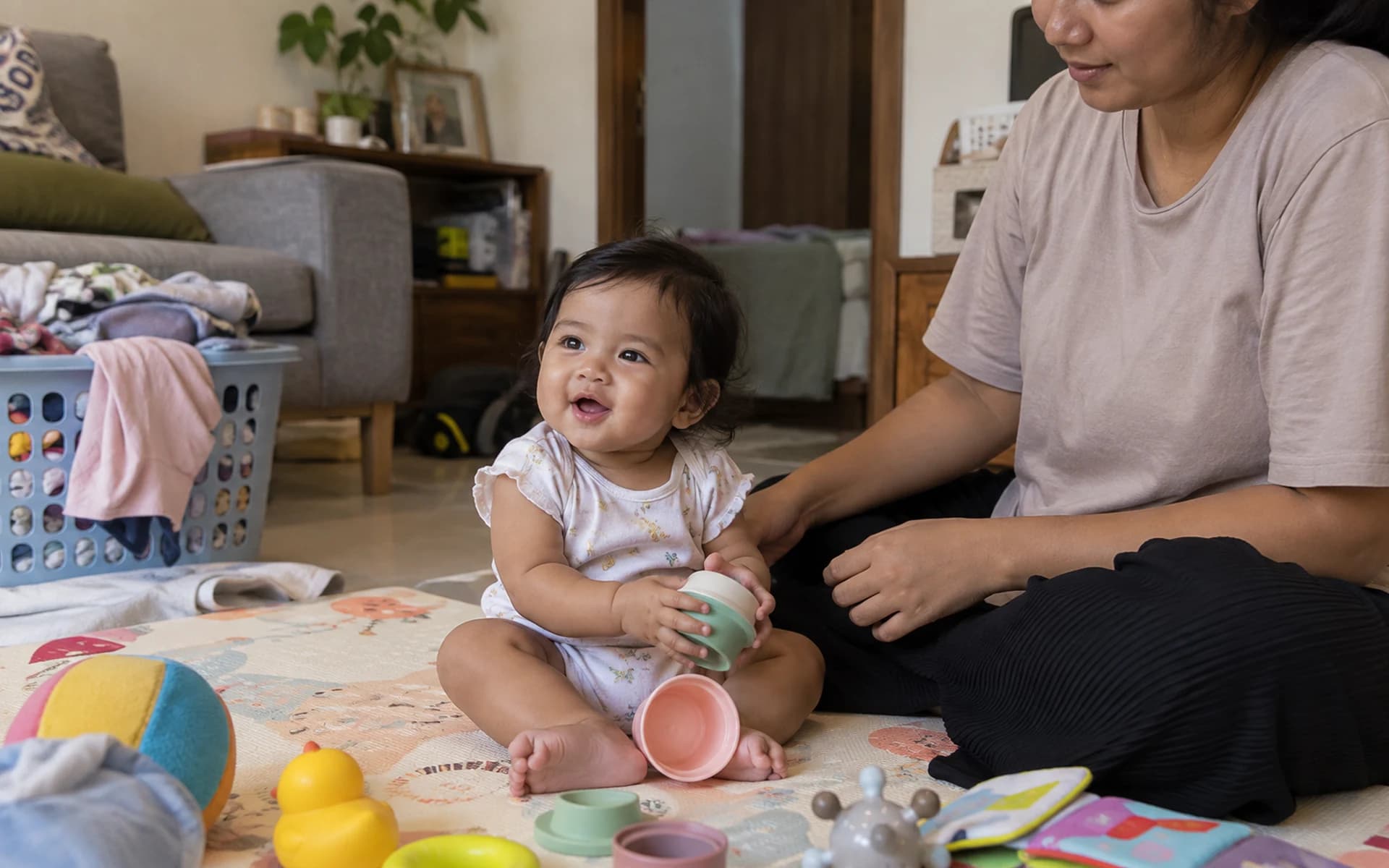 Bayi bermain di lantai bersama orang tuanya di rumah