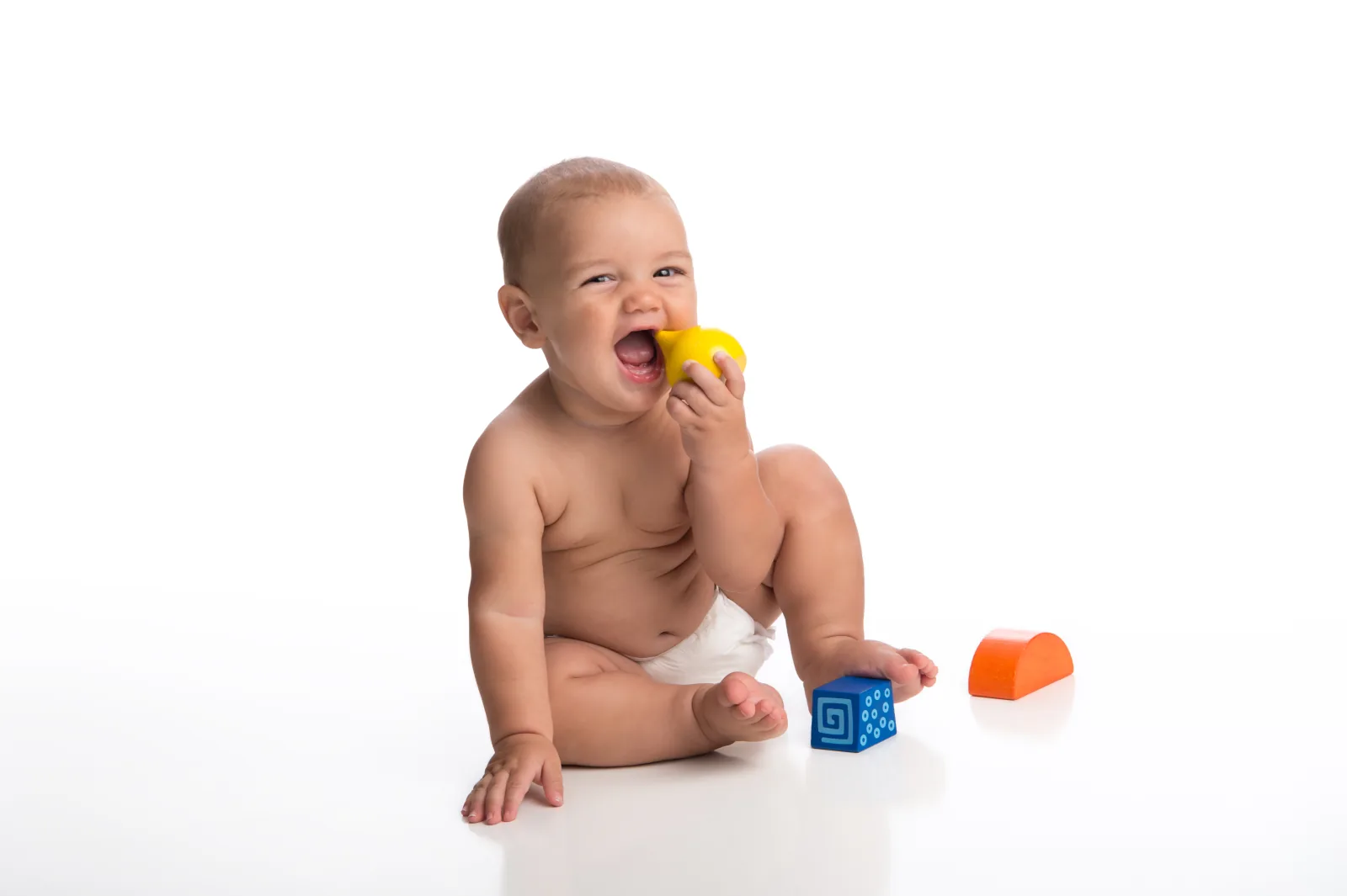 Bayi memasukkan mainan ke mulutnya