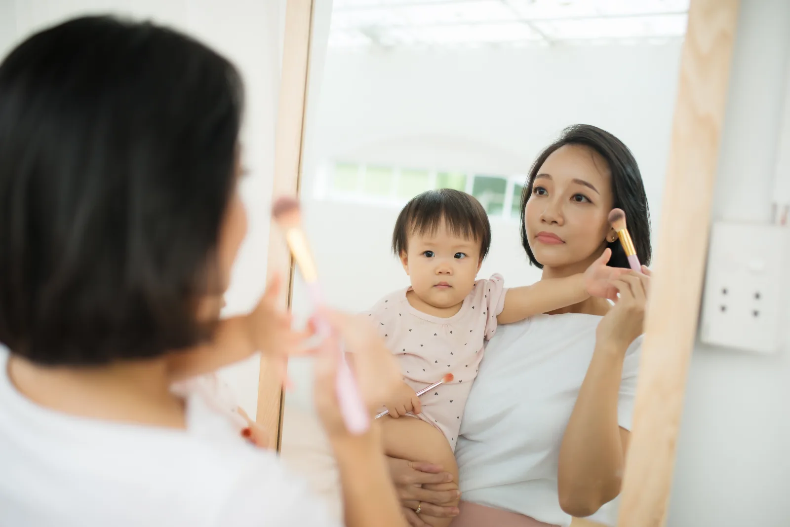 Ibu dan anak menyikat gigi di depan cermin