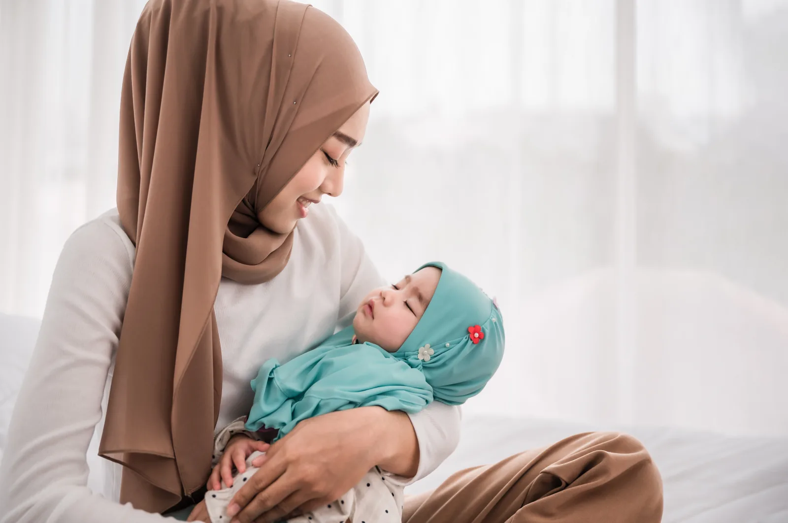 Ibu berhijab menggendong bayinya
