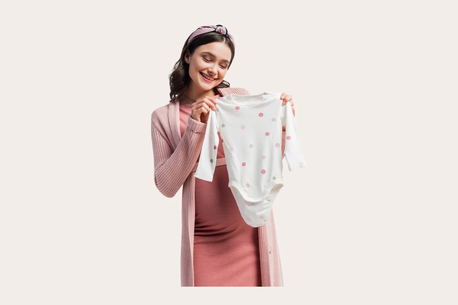 Ibu hamil memegang baju bayi