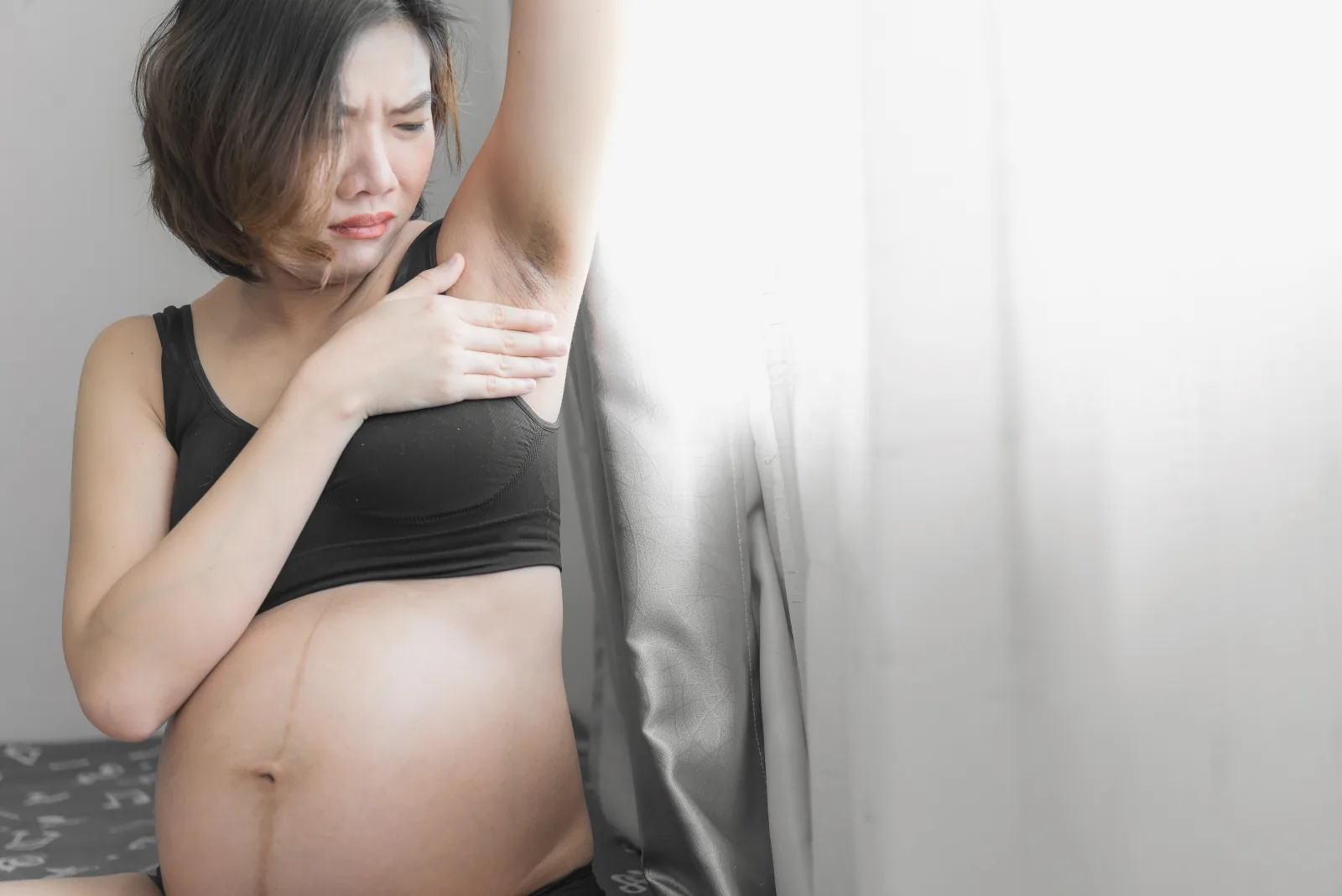 Pregnant woman checking her underarm