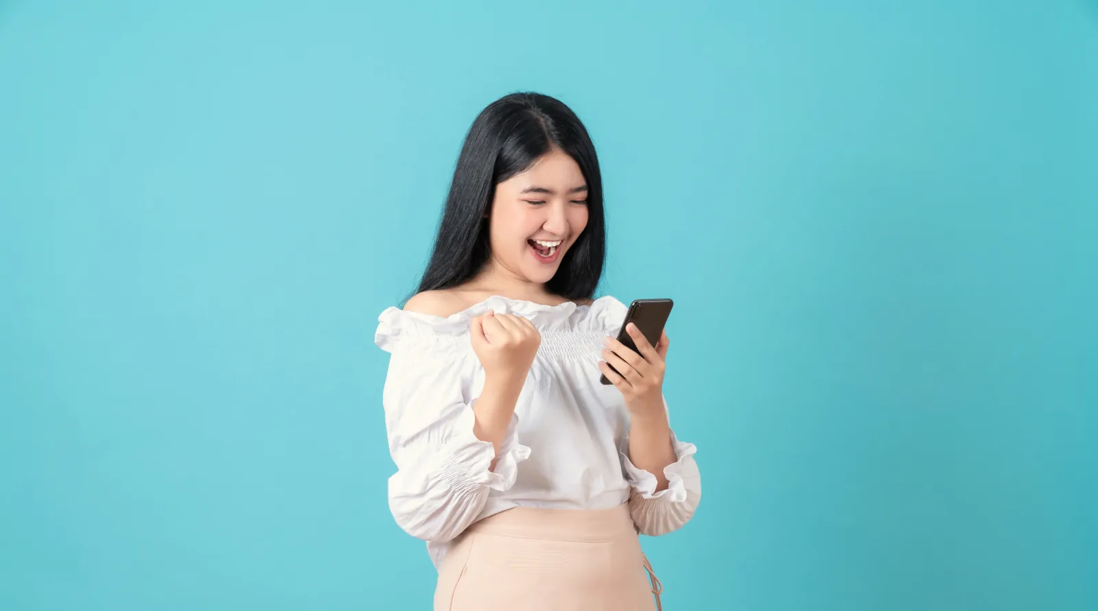 Ibu hamil tertawa sambil memegang ponsel