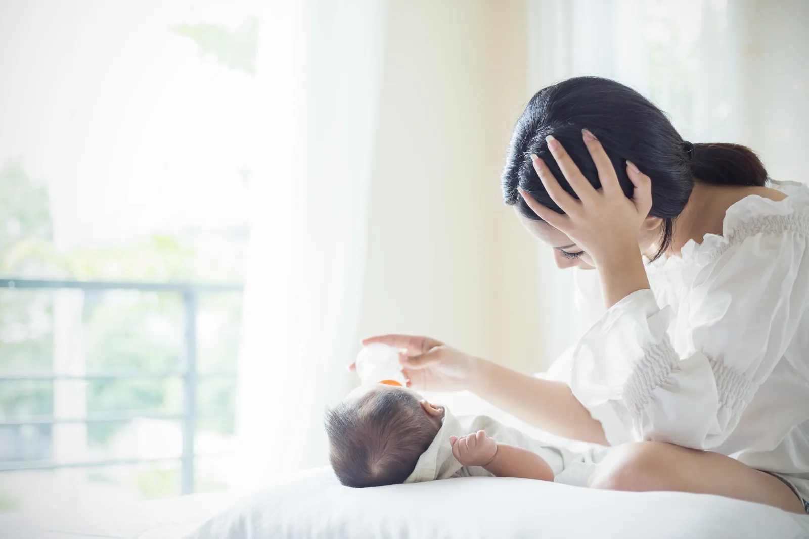 Ibu memberikan susu botol kepada bayinya