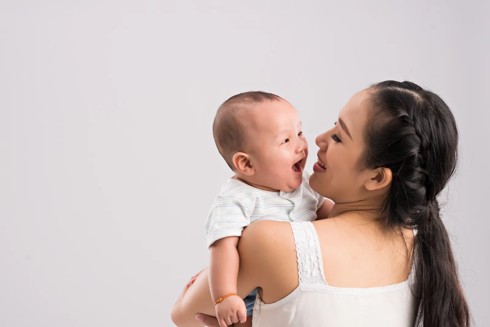 Ibu menggendong bayinya yang tertawa