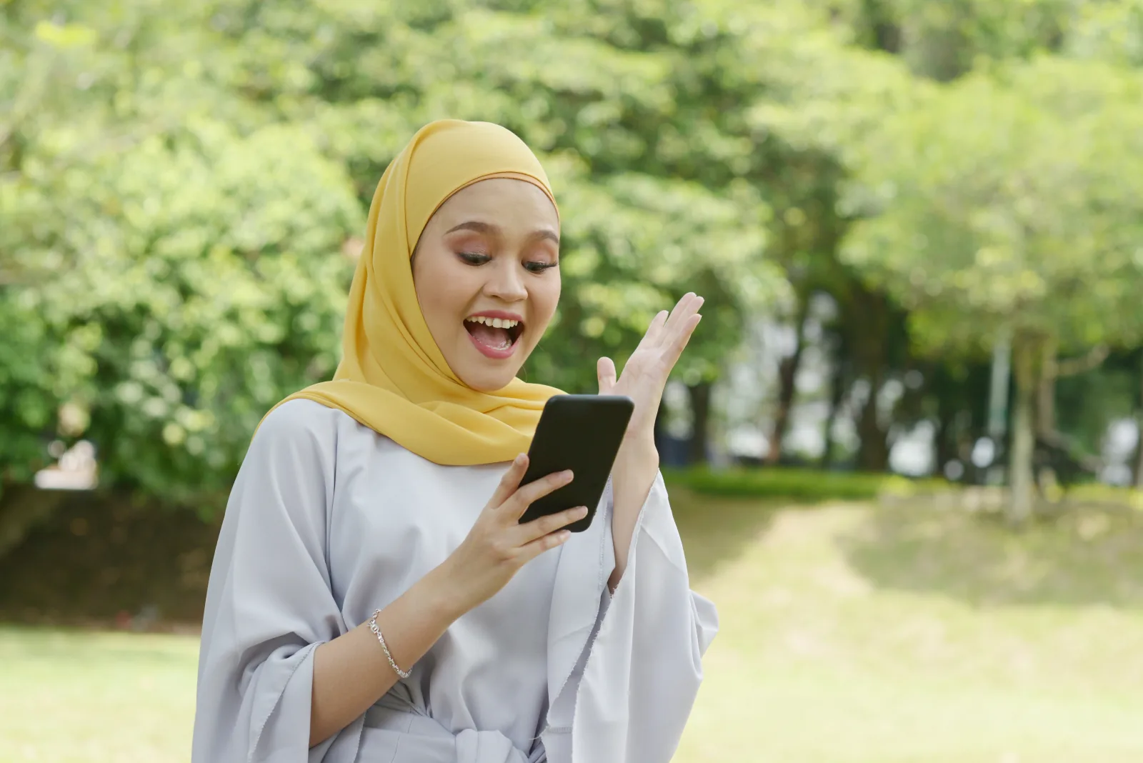 Perempuan berhijab melihat ponsel