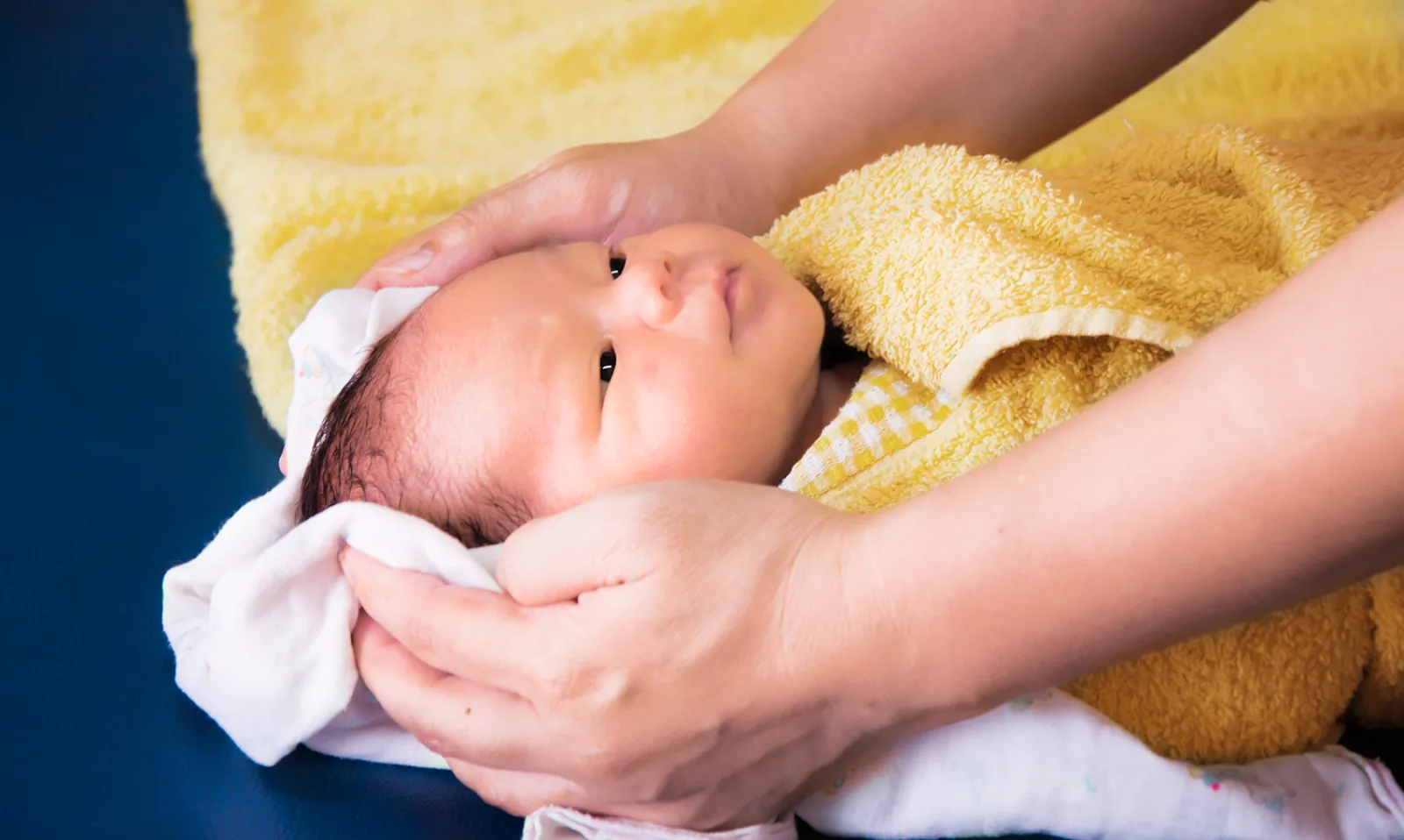 Rambut bayi dikeringkan dengan handuk