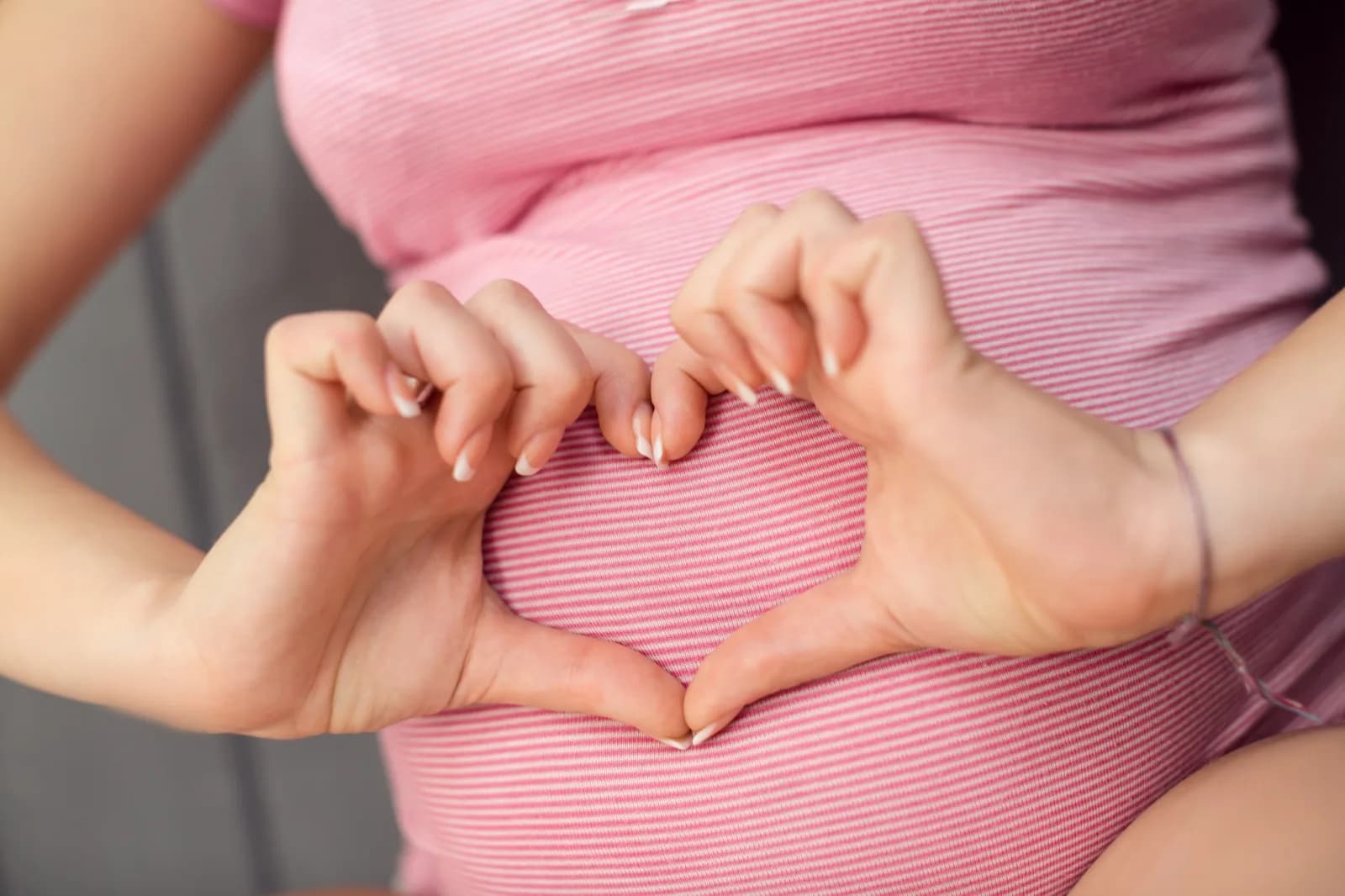 Tangan membentuk hati di perut kehamilan